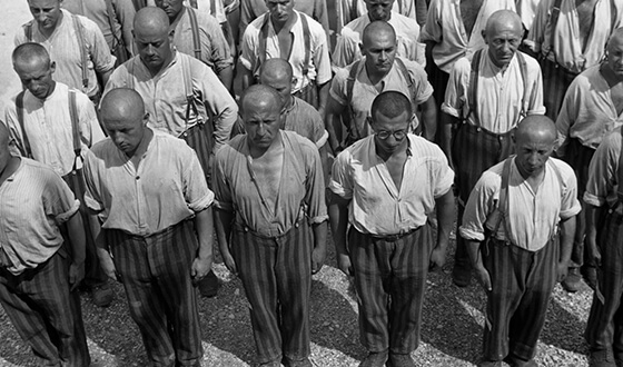Foto de prisioneros con las cabezas rapadas y vestidos con pantalones a rayas, de pie y quietos. Foto de propaganda de la SS (Derechos de imagen: Archivo Federal)