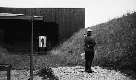 Hombre de la SS, que apunta con el brazo estirado y una pistola en la mano a un objetivo con contorno humano (Derechos de imagen: Heinz Bielmeier, Dachau).