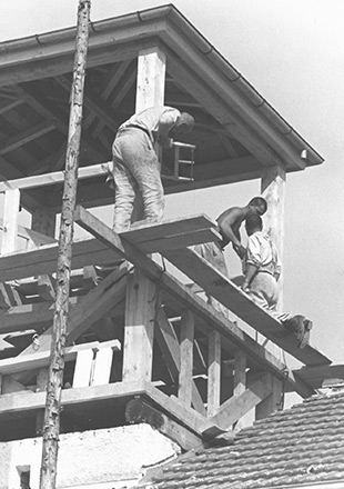 Tres prisioneros trabajando en la construcción de madera de la torre de vigilancia, que tuvieron que construir sobre el Jourhaus (antigua entrada al campo de prisioneros).